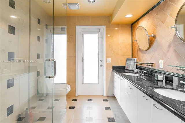 a bathroom with a double vanity sink mirror and shower
