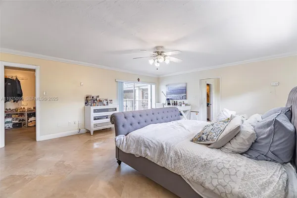 a bedroom with a large bed and a chandelier