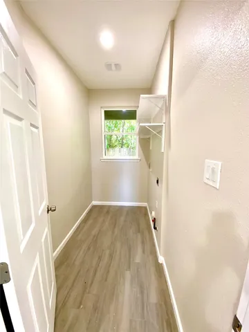 a view of hallway with a window and wooden floor