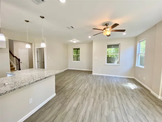 a view of a kitchen counter space with wooden floor and ceiling fan