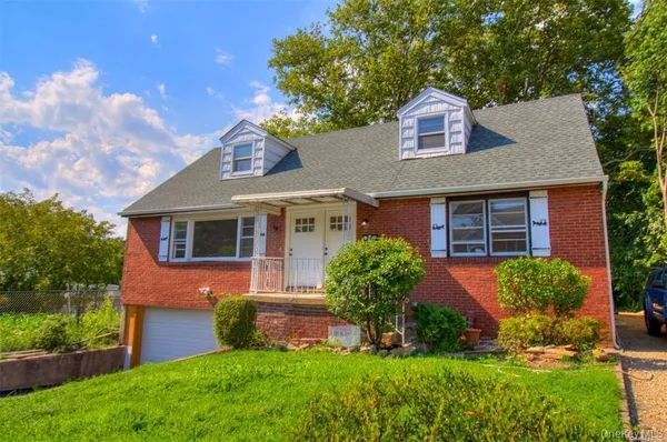 a front view of a house with a yard and potted plants