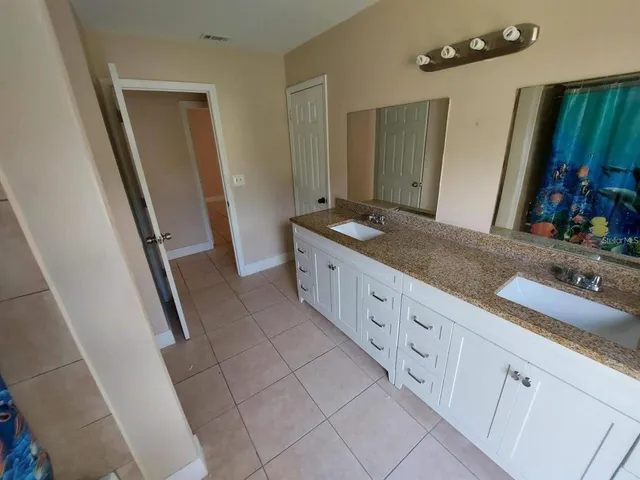 a spacious bathroom with a granite countertop sink and a mirror