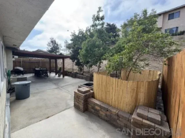 a view of a patio with table and chairs potted plants with wooden fence