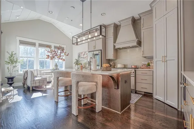 a kitchen with kitchen island white cabinets and stainless steel appliances