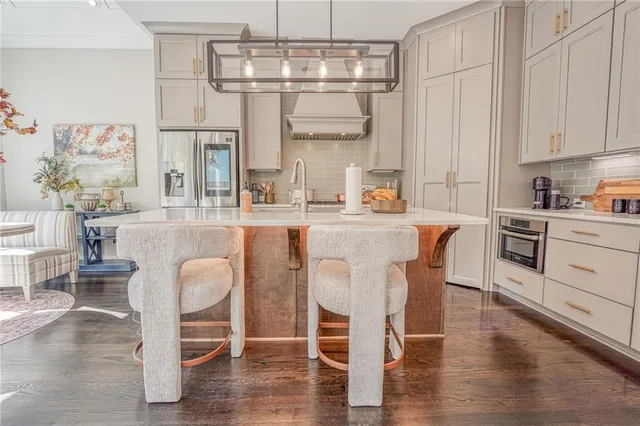 a kitchen with stainless steel appliances a dining table chairs and wooden floor