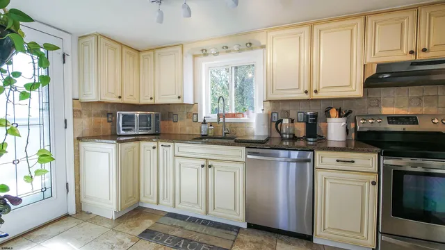 a kitchen with stainless steel appliances granite countertop a stove a sink and a microwave