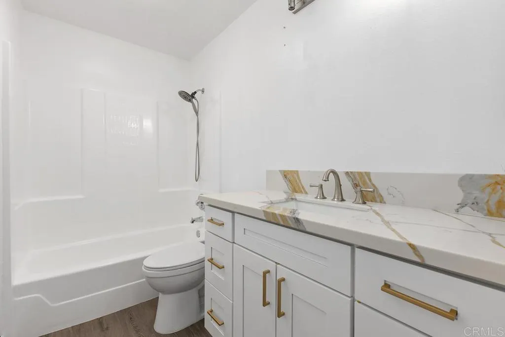 889 Bracero Road Encinitas, CA 92024 - Photo 43 of 59 a bathroom with a granite countertop sink a toilet and bathtub
