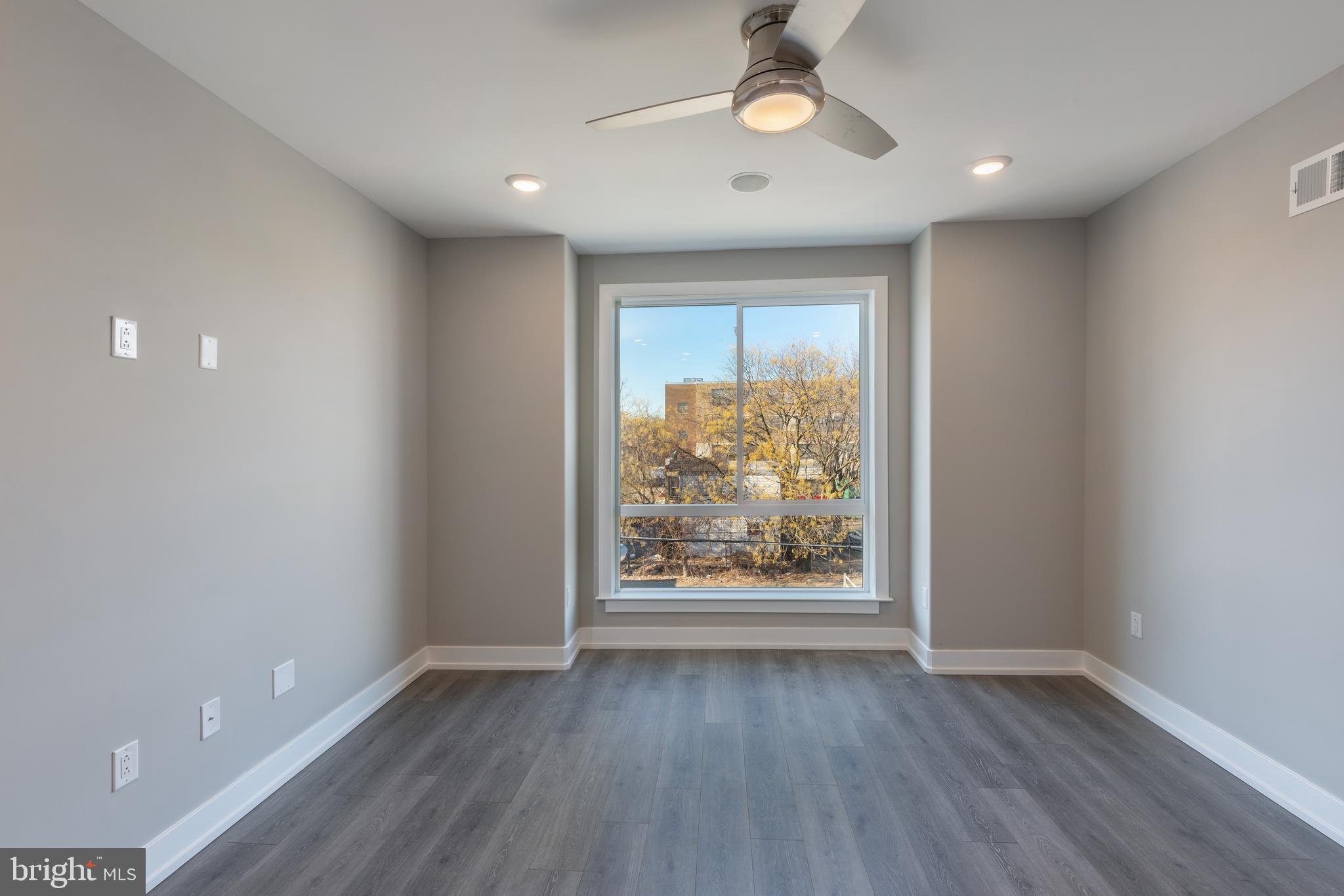 2327 North 3rd Street Philadelphia, PA 19133 - Photo 1 of 28 an empty room with wooden floor chandelier fan and windows