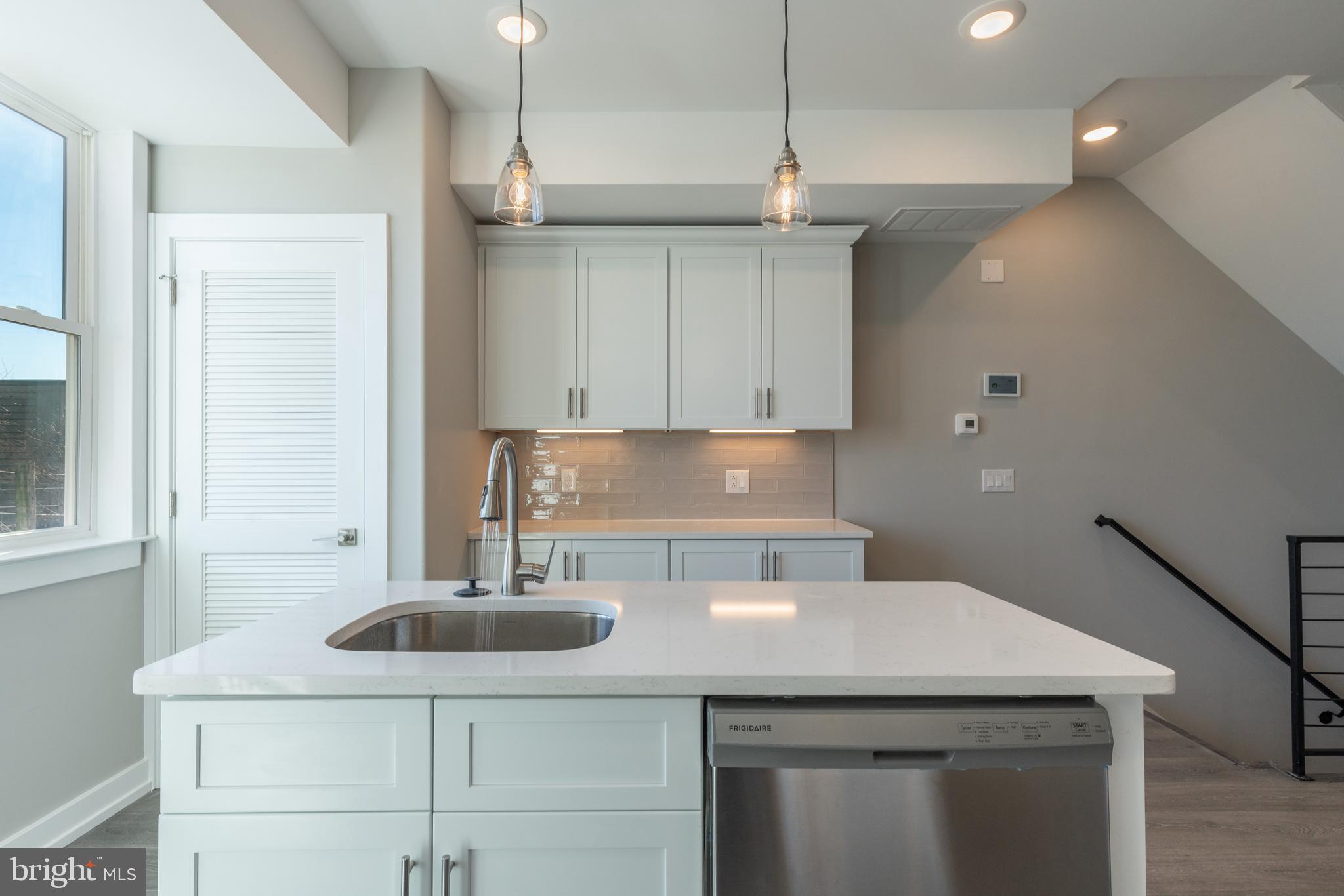 2327 North 3rd Street Philadelphia, PA 19133 - Photo 6 of 28 a kitchen with a sink a refrigerator and cabinets
