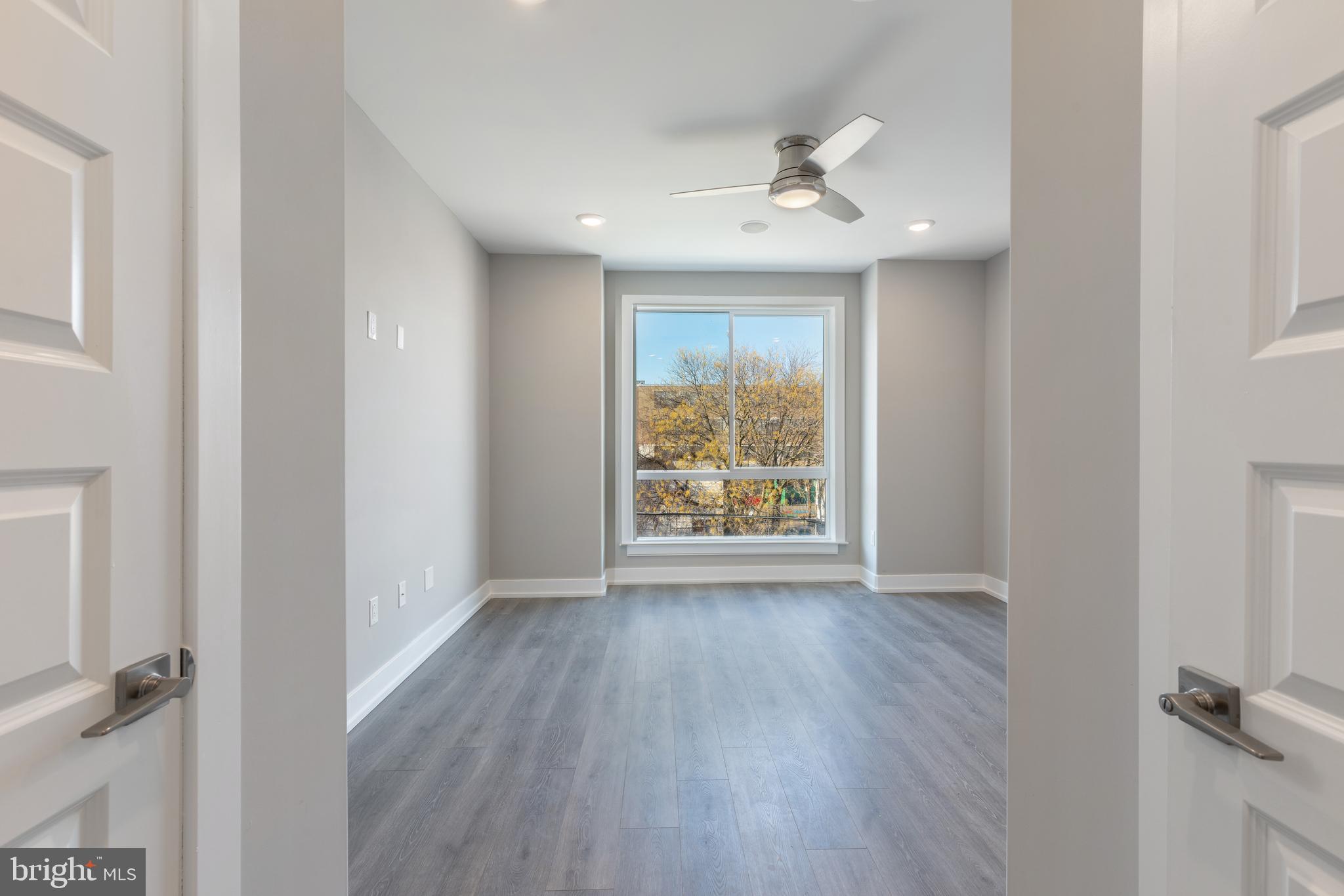 2327 North 3rd Street Philadelphia, PA 19133 - Photo 8 of 28 an empty room with wooden floor fan and windows