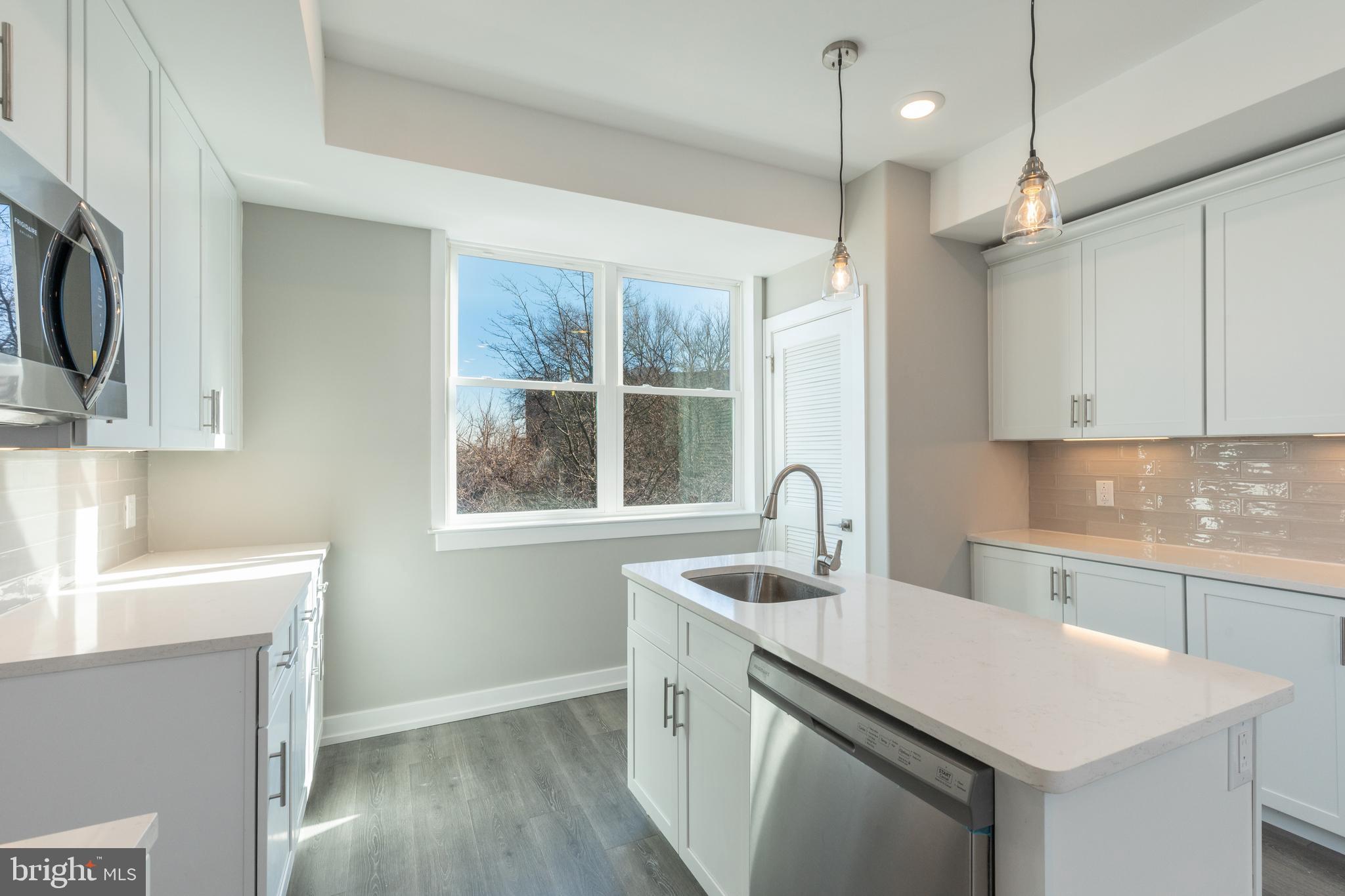2327 North 3rd Street Philadelphia, PA 19133 - Photo 10 of 28 a kitchen with stainless steel appliances granite countertop a sink a stove and a refrigerator