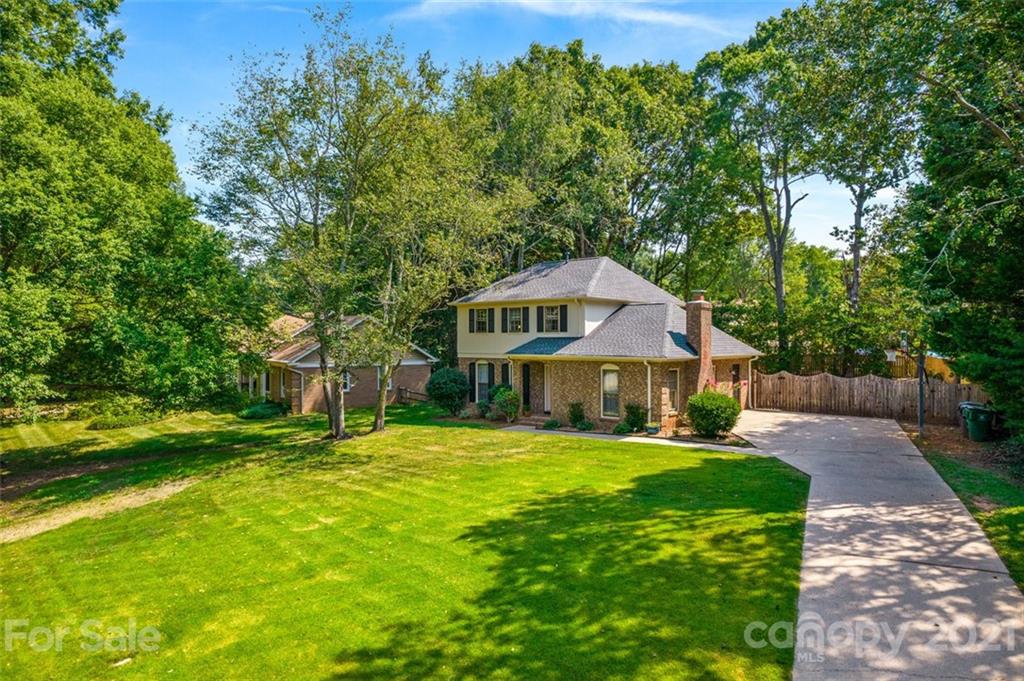 a house that has a big yard with large trees