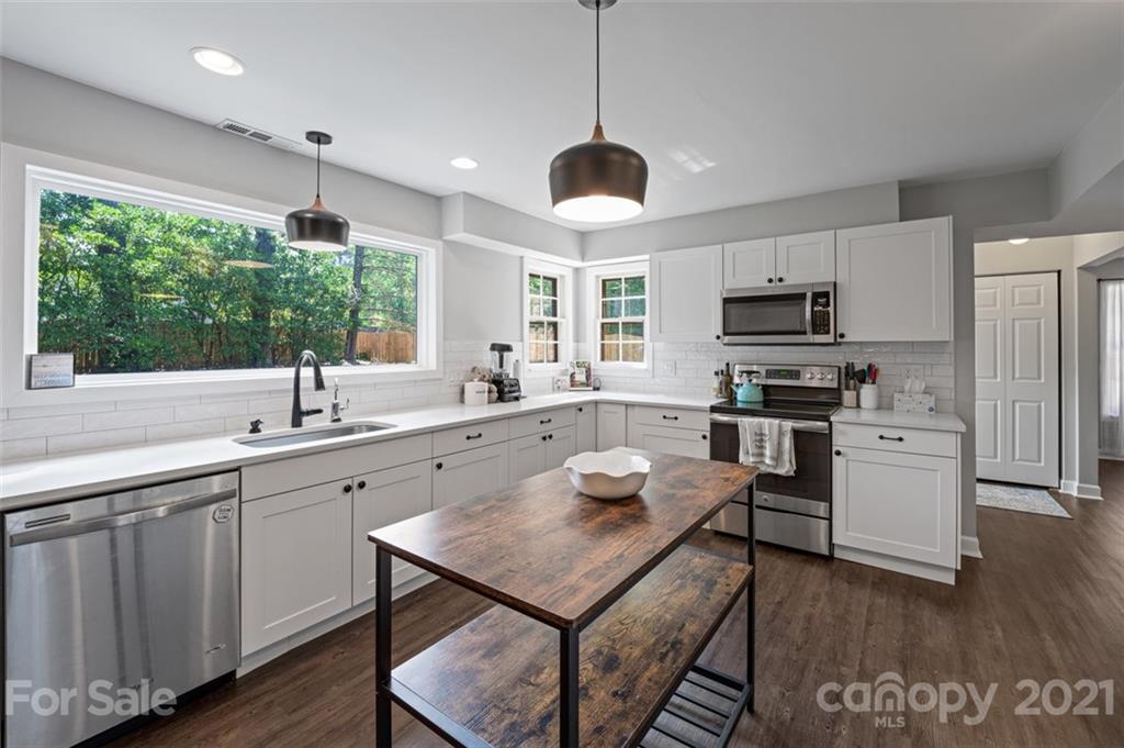 10017 Sardis Oaks Road Charlotte, NC 28270 - Photo 10 of 31 a open kitchen with stainless steel appliances granite countertop a sink a stove and a refrigerator with wooden floor