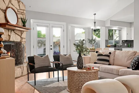 a living room with furniture a chandelier and a window