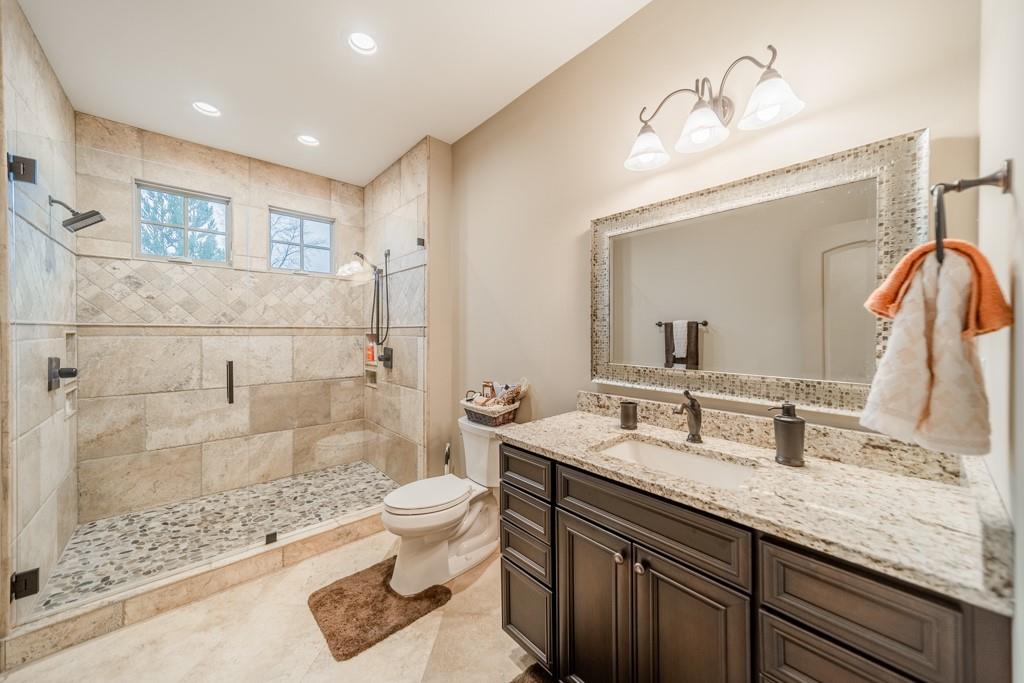 16339 Jetton Road Cornelius, NC 28031 - Photo 40 of 48 a bathroom with a granite countertop sink a toilet a mirror and shower