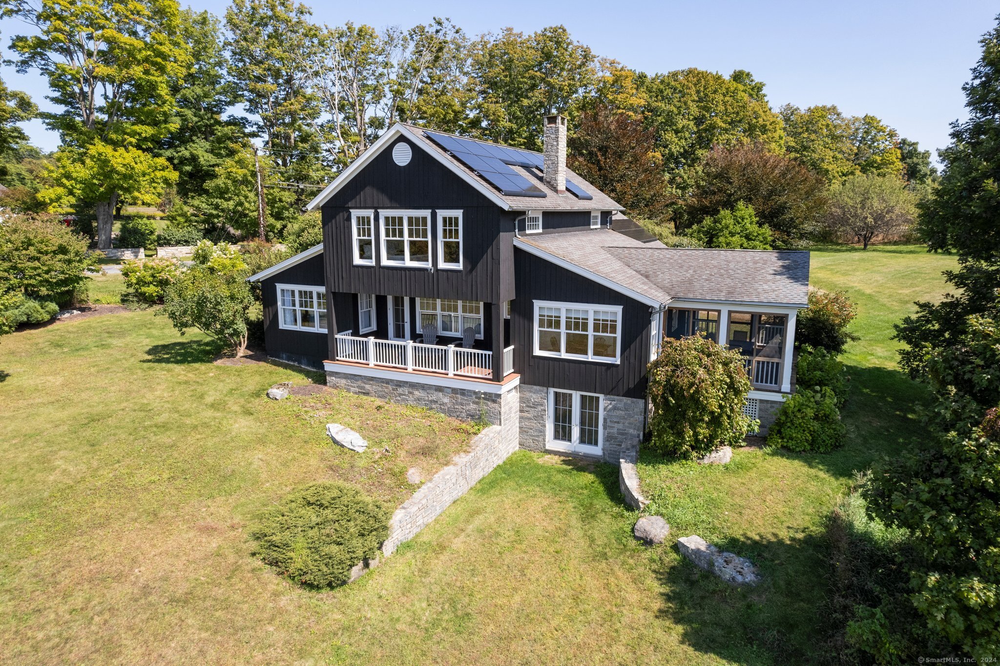 74 Tanner Hill Road Warren, CT 06777 - Photo 6 of 40 a front view of a house with a yard table and chairs