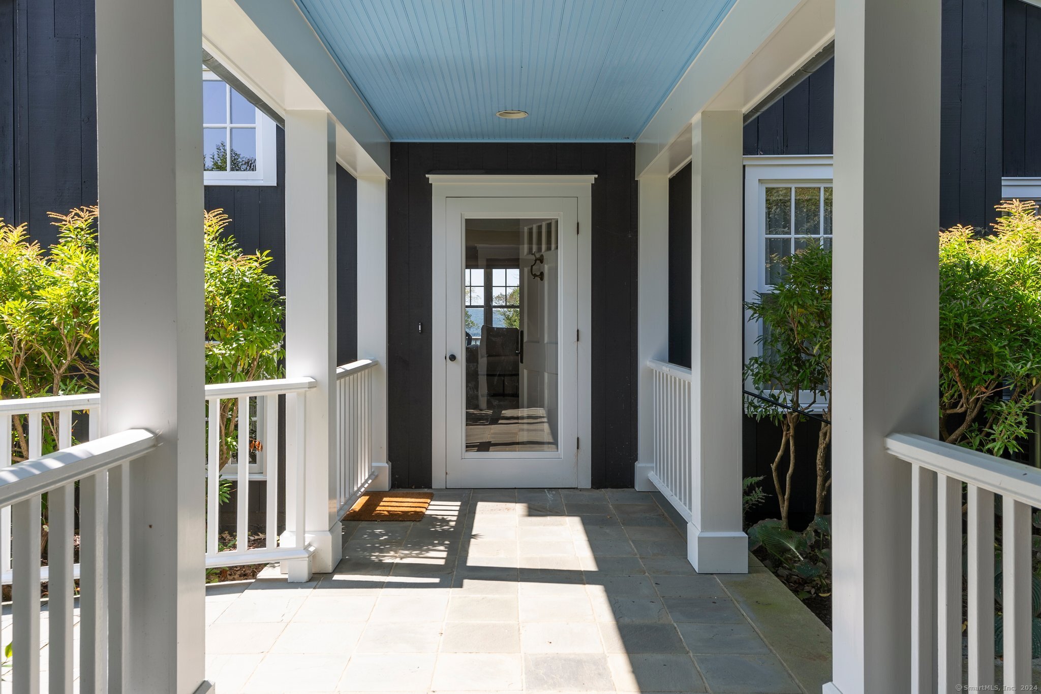 74 Tanner Hill Road Warren, CT 06777 - Photo 8 of 40 a front view of a house with a large window and potted plants