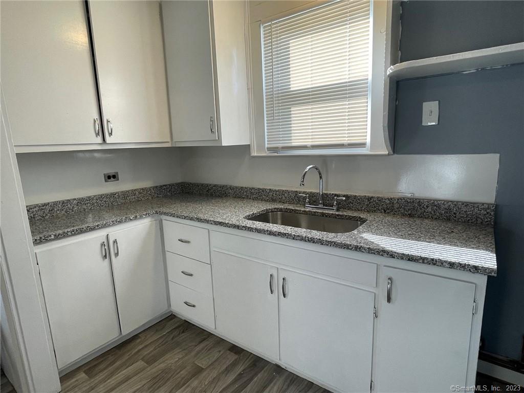 79 River Street, Unit 79 Sprague, CT 06330 - Photo 10 of 25 a kitchen with granite countertop white cabinets and sink