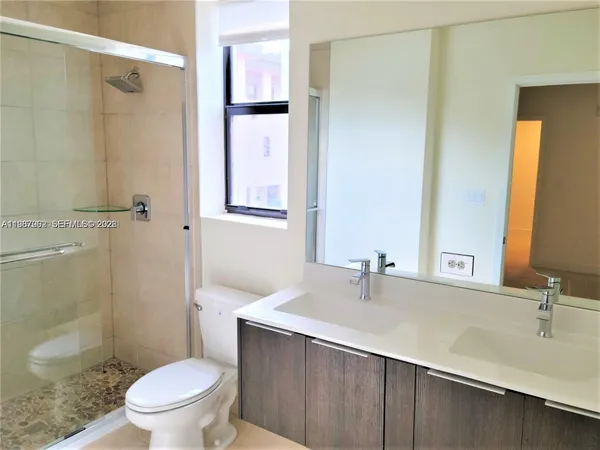 a bathroom with a sink toilet a mirror and shower