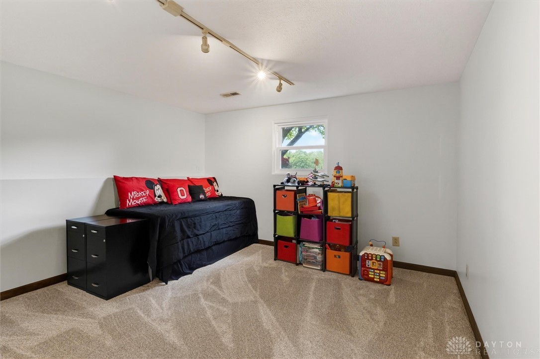 2165 Stewart Road Xenia, OH 45385 - Photo 24 of 59 This cozy bedroom features plush carpeting and track lighting, creating a comfortable and inviting atmosphere.