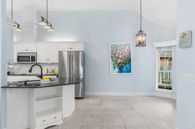 a kitchen with granite countertop white cabinets and stainless steel appliances