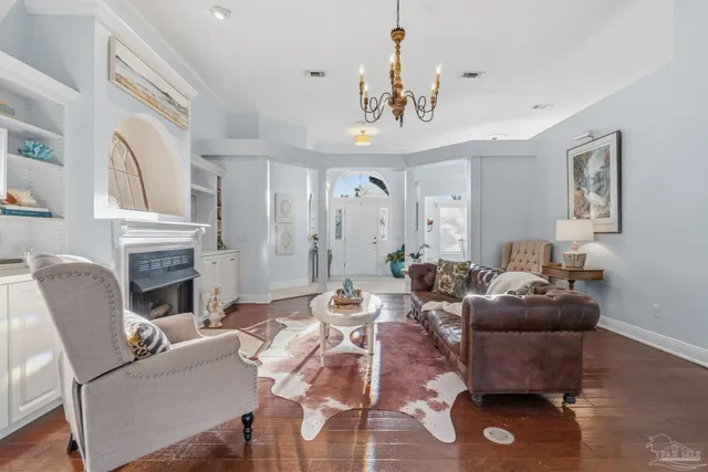 a large white kitchen with stainless steel appliances a refrigerator a stove a sink and a chandelier