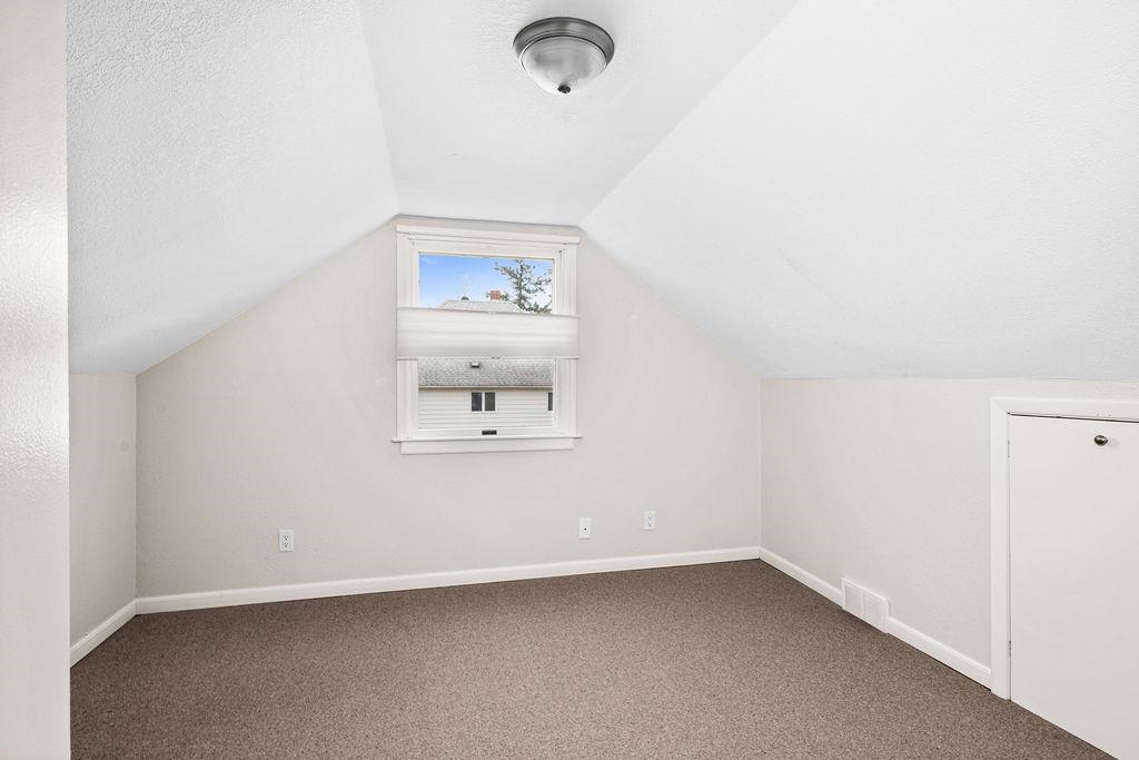 5007 Colorado Street Duluth, MN 55804 - Photo 18 of 31 Bonus room with carpet flooring, lofted ceiling, and a textured ceiling