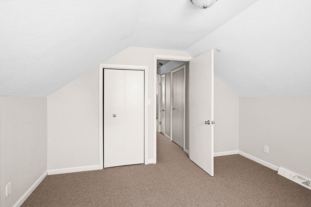 5007 Colorado Street Duluth, MN 55804 - Photo 19 of 31 Additional living space featuring a textured ceiling, carpet, and vaulted ceiling