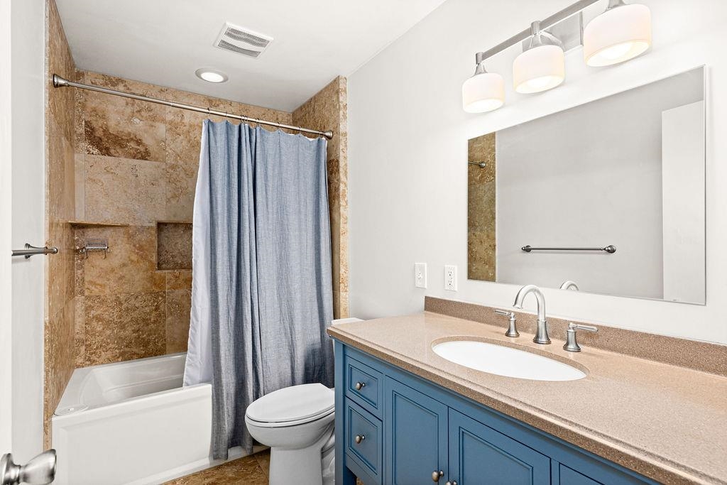 5007 Colorado Street Duluth, MN 55804 - Photo 20 of 31 Bathroom featuring shower / tub combo with curtain, vanity, and dark tile patterned floors