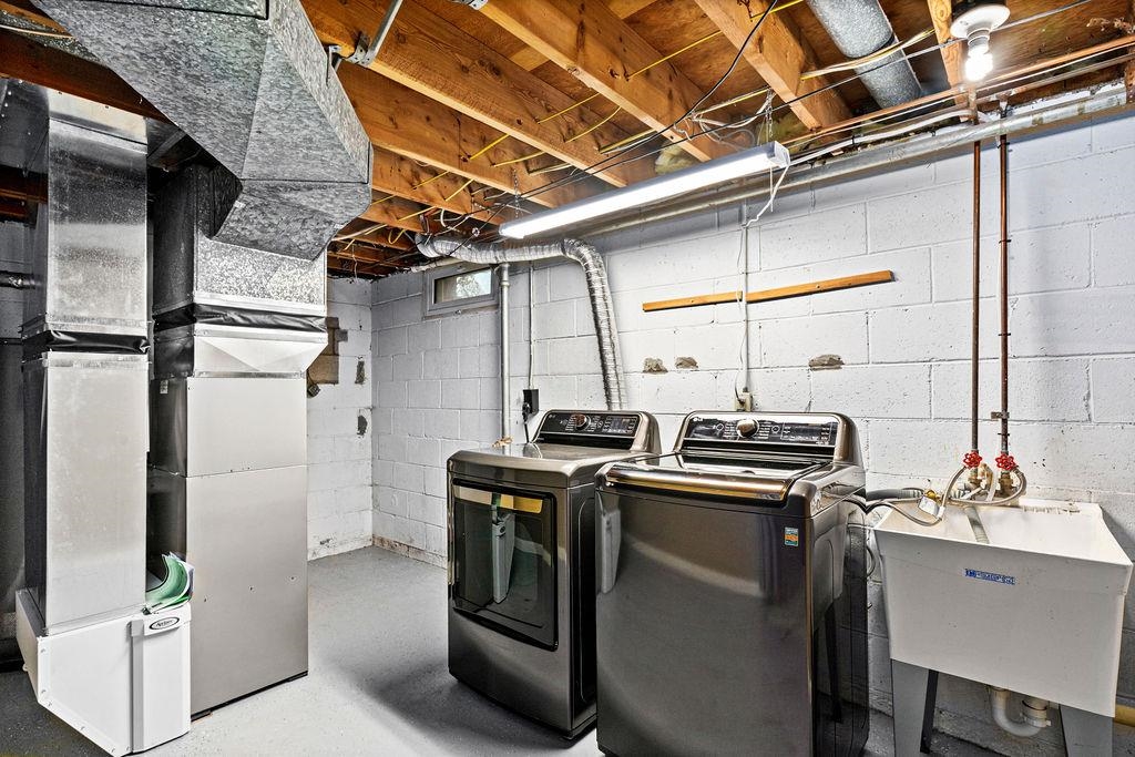 5007 Colorado Street Duluth, MN 55804 - Photo 23 of 31 Laundry room featuring heating unit, washing machine and dryer, and finished concrete flooring