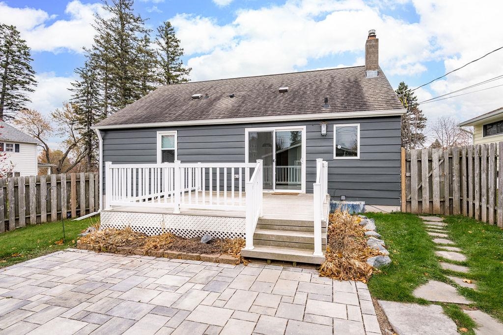 5007 Colorado Street Duluth, MN 55804 - Photo 25 of 31 Back of property with a fenced backyard, a deck, a chimney, and a shingled roof