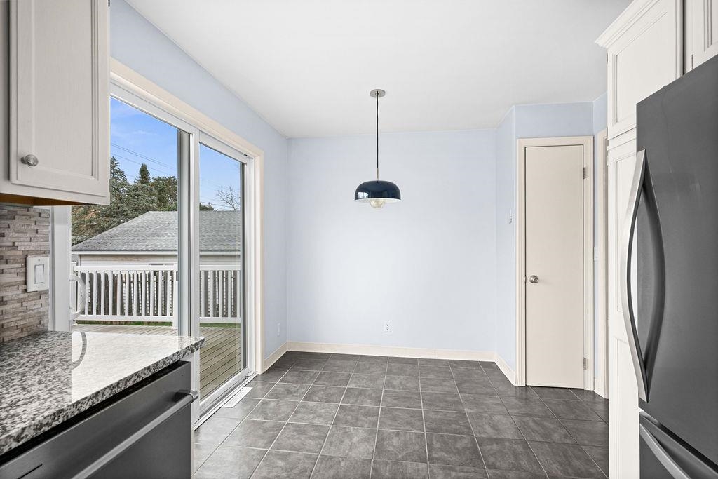 5007 Colorado Street Duluth, MN 55804 - Photo 4 of 31 Unfurnished dining area featuring baseboards and dark tile patterned flooring