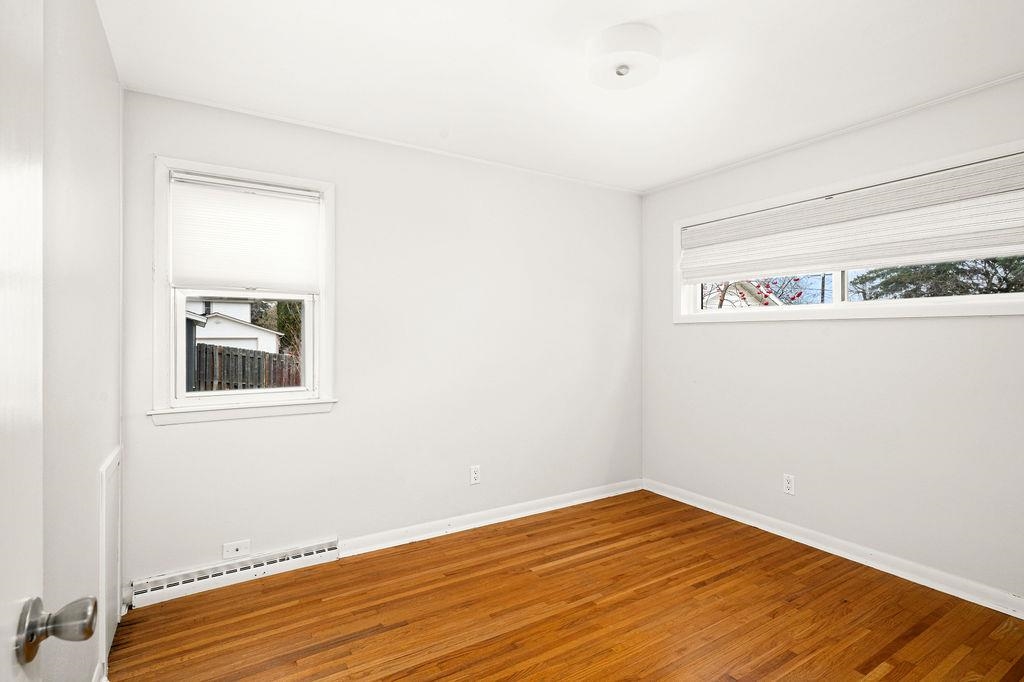 5007 Colorado Street Duluth, MN 55804 - Photo 9 of 31 Spare room with wood finished floors, baseboard heating, and plenty of natural light