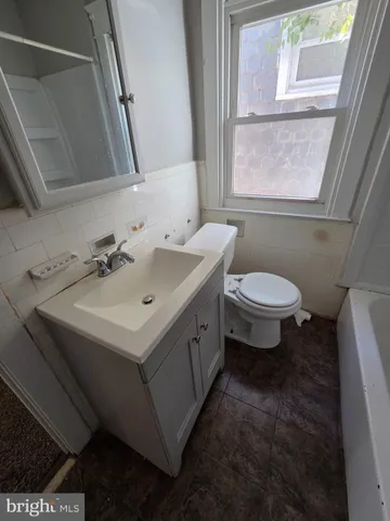 a bathroom with a sink toilet and window