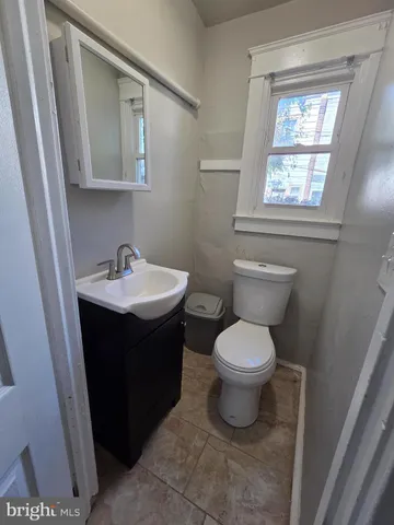 a bathroom with a sink toilet and window