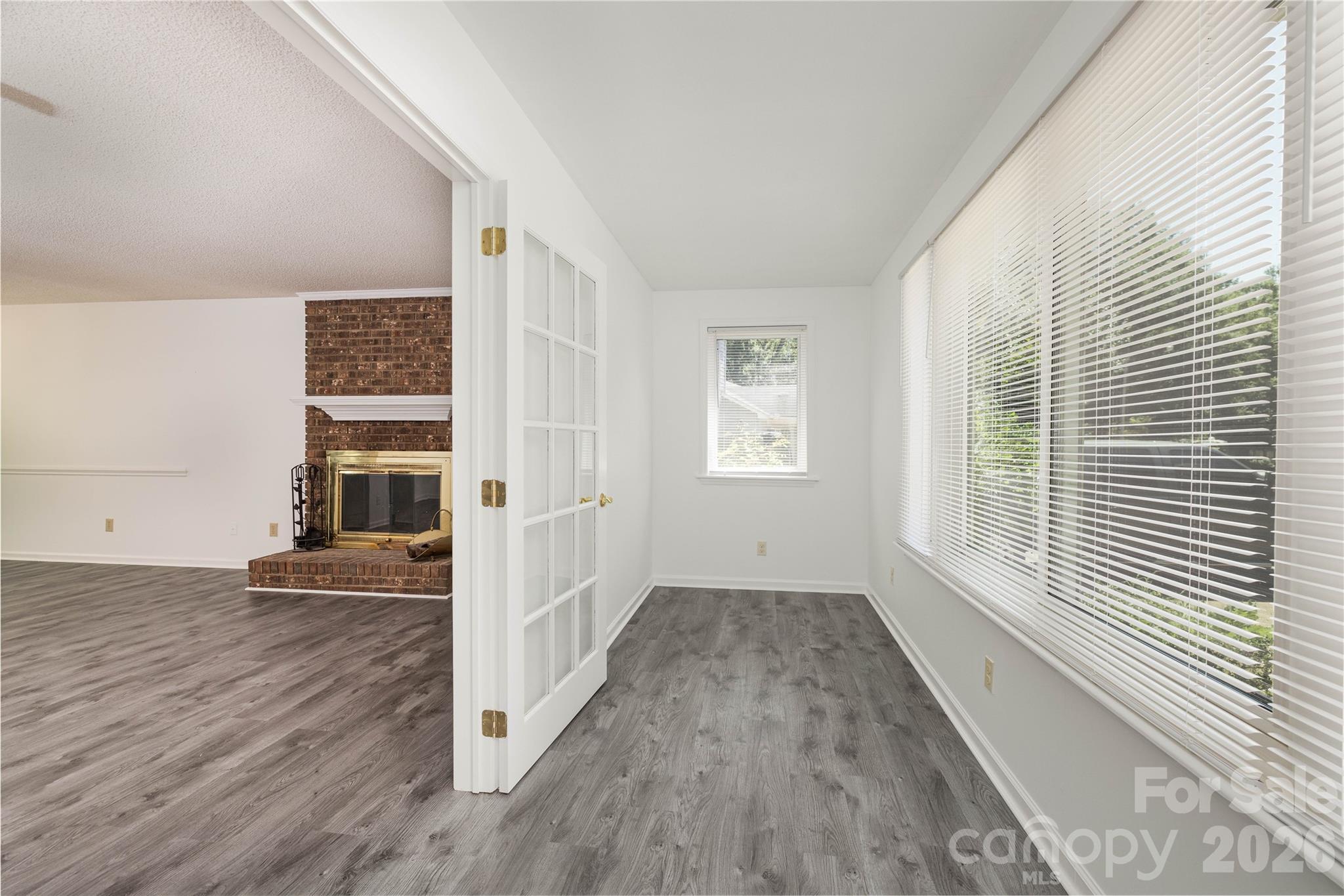 21014 Pine Ridge Drive Cornelius, NC 28031 - Photo 14 of 26 an empty room with wooden floor and windows