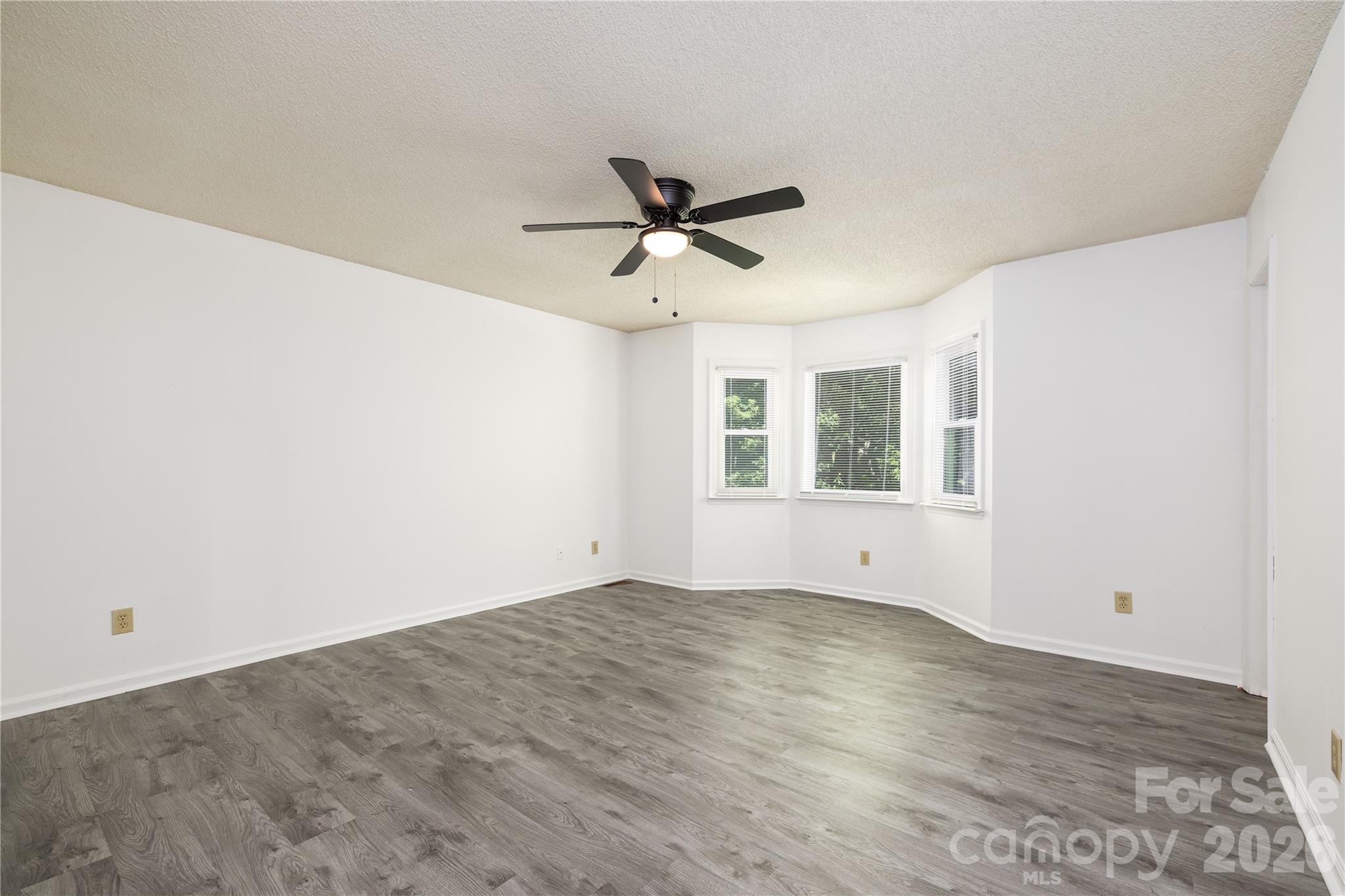 21014 Pine Ridge Drive Cornelius, NC 28031 - Photo 15 of 26 a view of empty room with wooden floor and fan