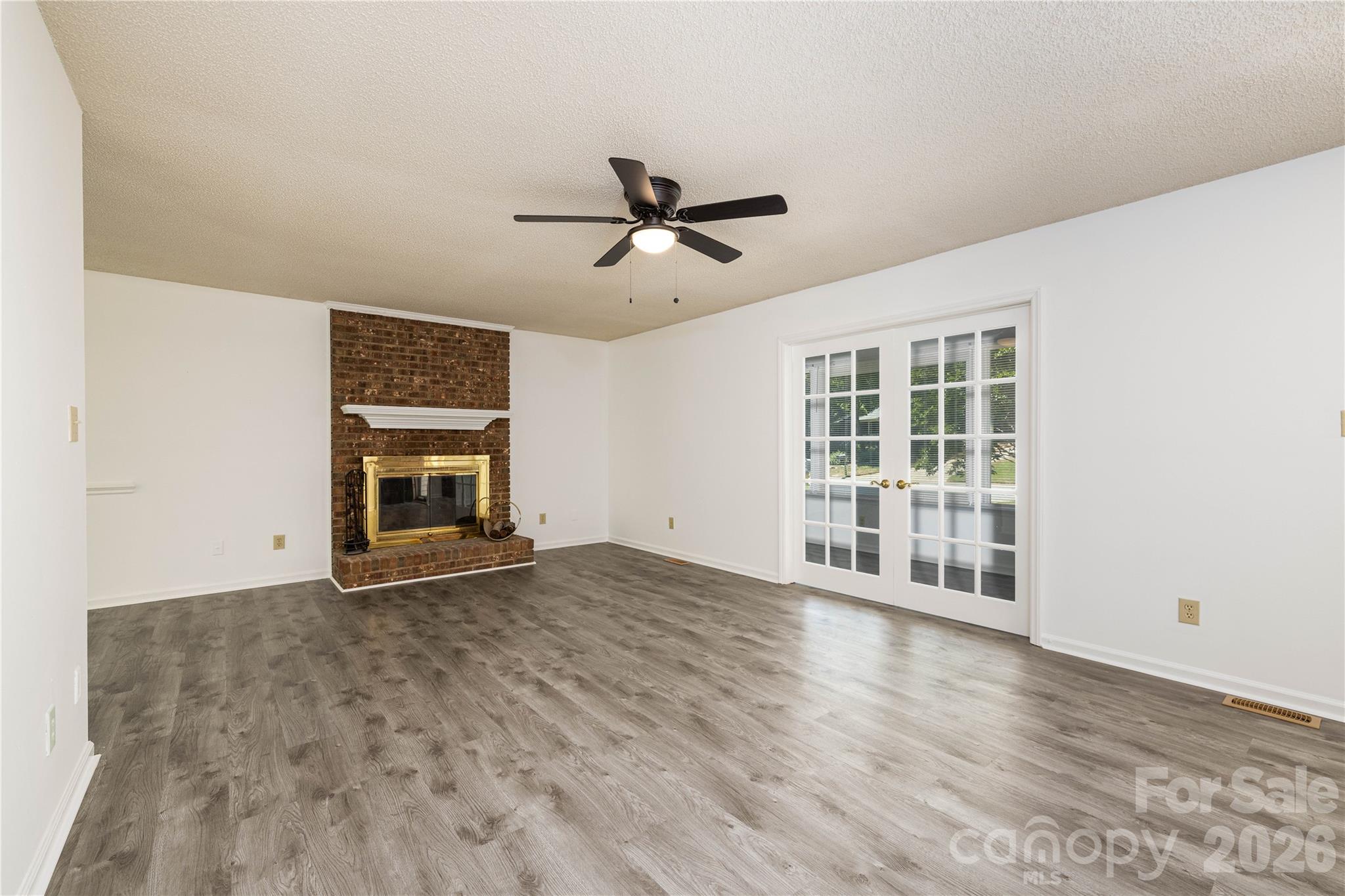 21014 Pine Ridge Drive Cornelius, NC 28031 - Photo 3 of 26 an empty room with wooden floor ceiling fan and windows