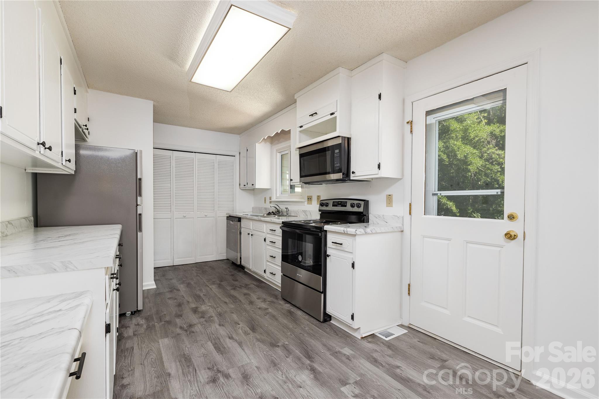 21014 Pine Ridge Drive Cornelius, NC 28031 - Photo 6 of 26 a kitchen with white cabinets and appliances