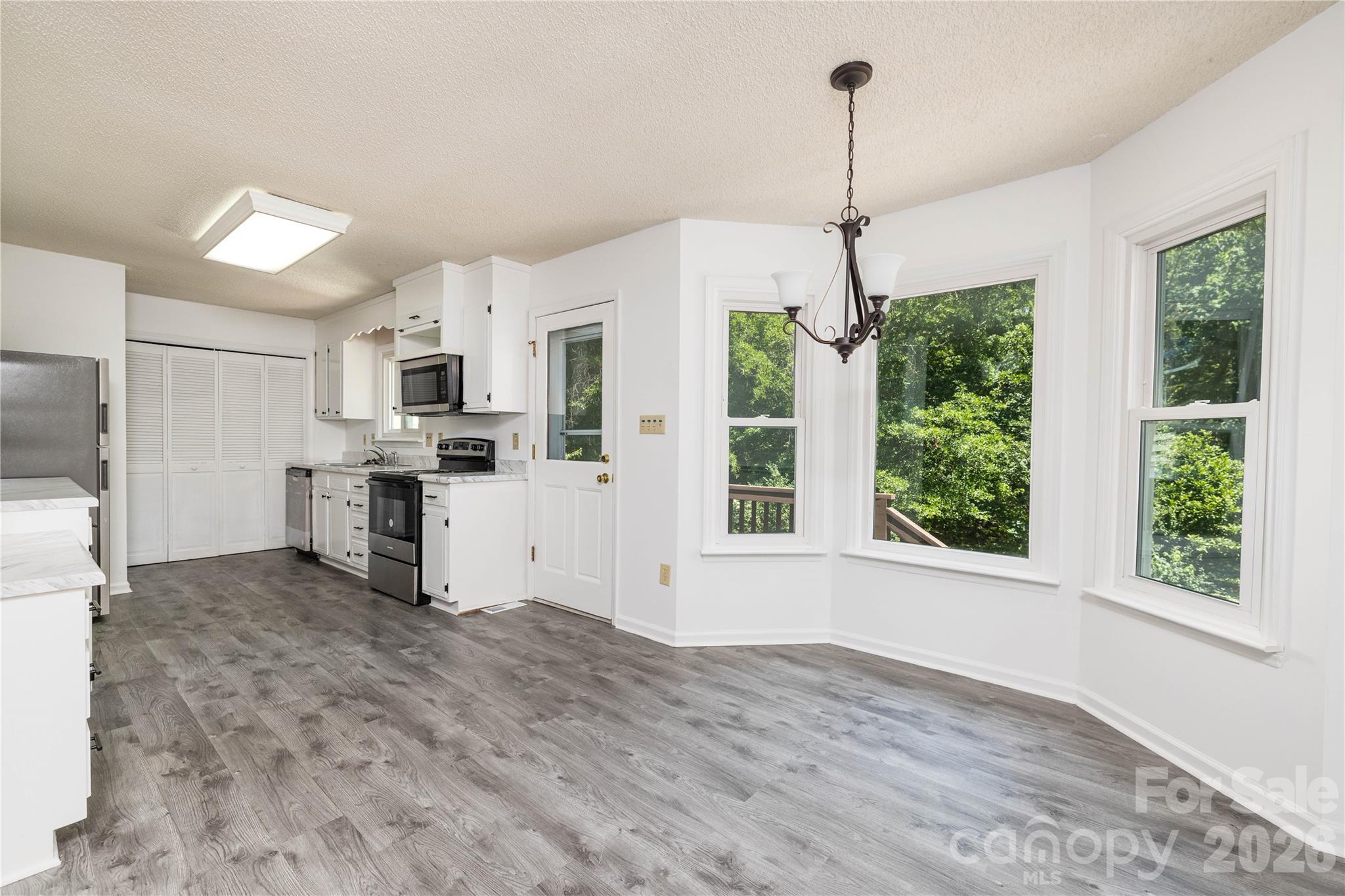 21014 Pine Ridge Drive Cornelius, NC 28031 - Photo 7 of 26 a kitchen with stainless steel appliances granite countertop a refrigerator a sink a stove and white cabinets with wooden floor