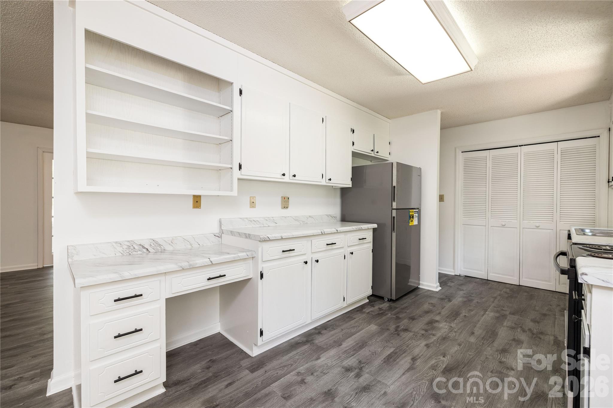 21014 Pine Ridge Drive Cornelius, NC 28031 - Photo 8 of 26 a kitchen with granite countertop white cabinets and refrigerator