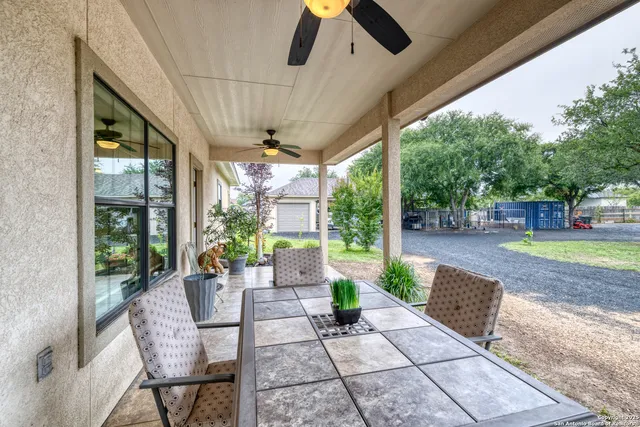 a view of a patio with a table chairs and a backyard