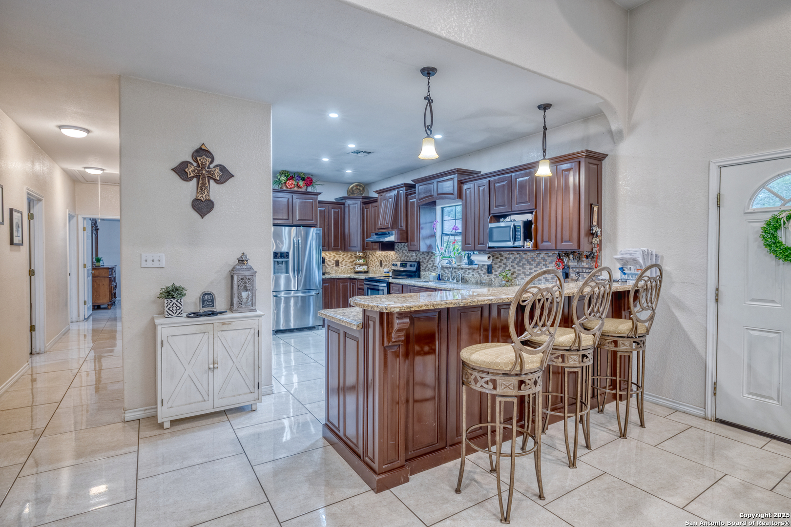333 Studer Street Uvalde, TX 78801 - Photo 5 of 29 a kitchen with stainless steel appliances granite countertop a table and chairs in it