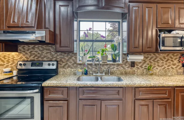 a kitchen with sink a window and cabinets