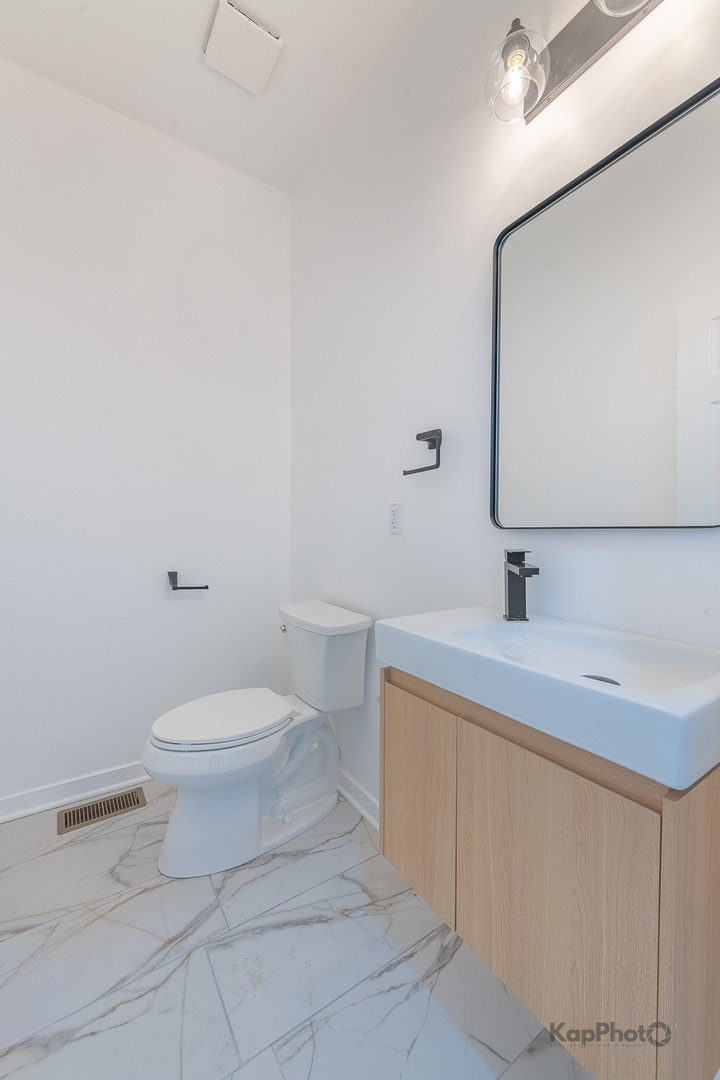 2139 West 24th Street Chicago, IL 60608 - Photo 20 of 29 a bathroom with a sink a toilet and mirror