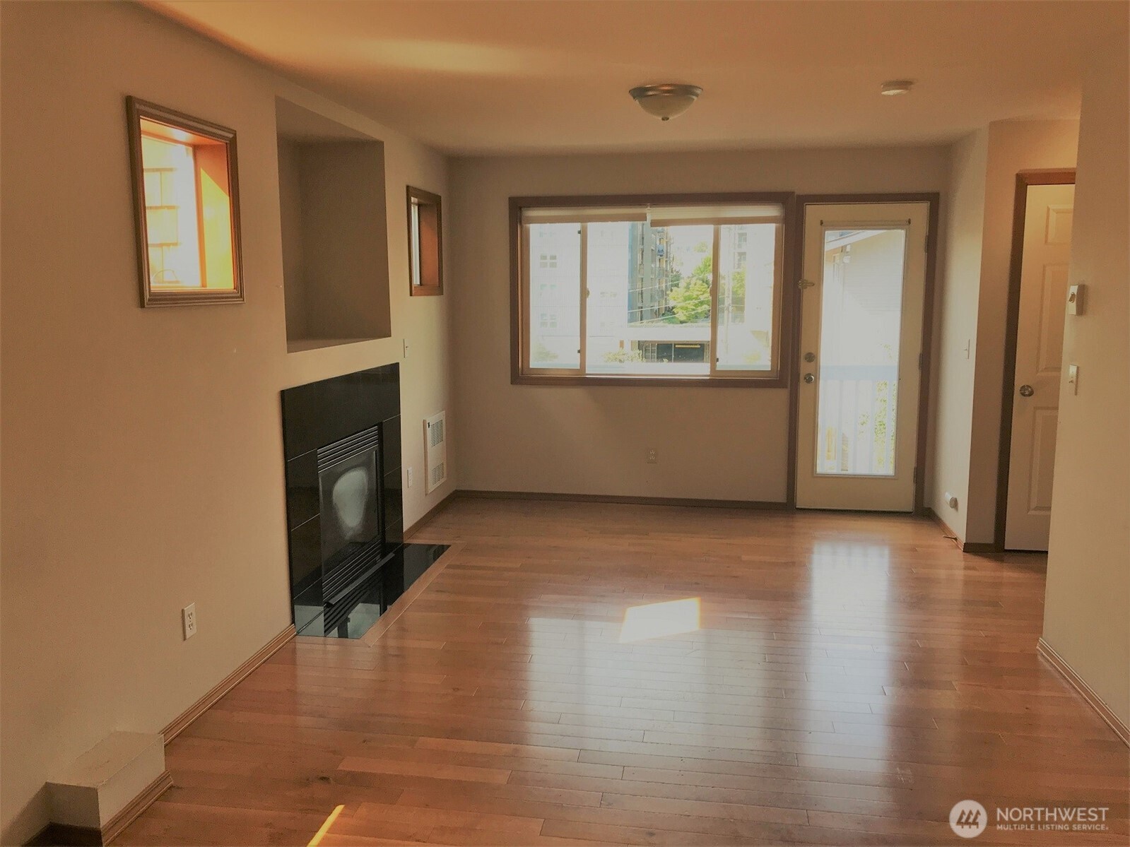 12723 35th Avenue Northeast, Unit A Seattle, WA 98125 - Photo 2 of 11 a view of an empty room with wooden floor and a window