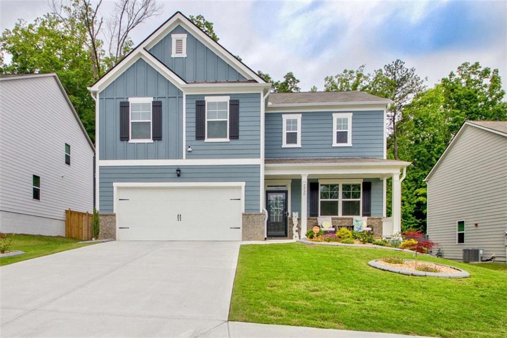 7730 Demeter Drive Fairburn, GA 30213 - Photo 1 of 37 a front view of a house with a yard and garage