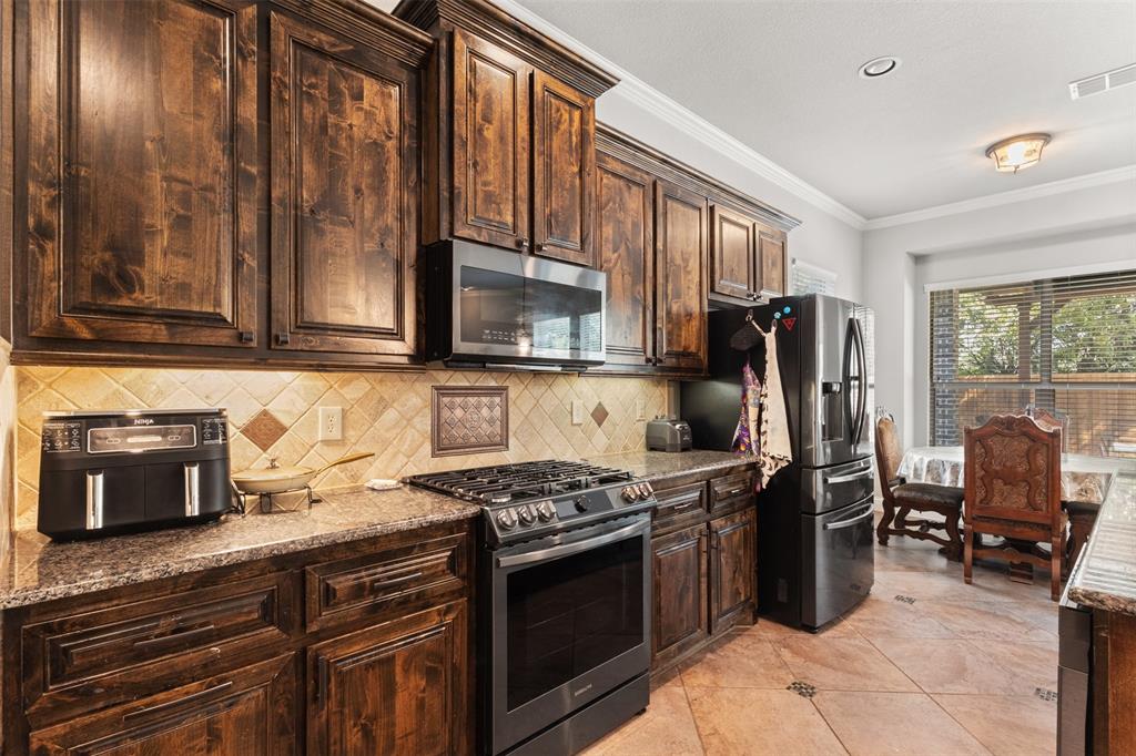 800 Goose Court Forney, TX 75126 - Photo 12 of 34 a kitchen with stainless steel appliances granite countertop a stove refrigerator and microwave
