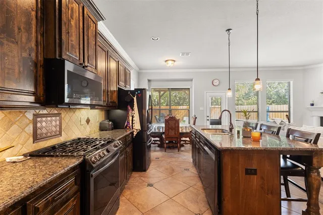 a kitchen with stainless steel appliances granite countertop a stove refrigerator and microwave