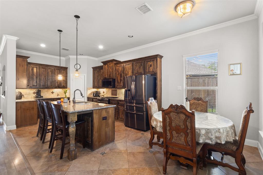 800 Goose Court Forney, TX 75126 - Photo 17 of 34 a kitchen with a table chairs refrigerator and microwave